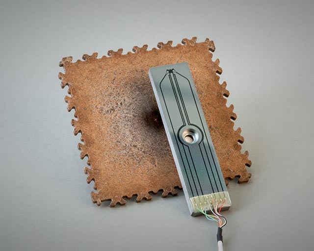 Wood-fiber-reinforced injection-molded part with corresponding sensor module for production monitoring.