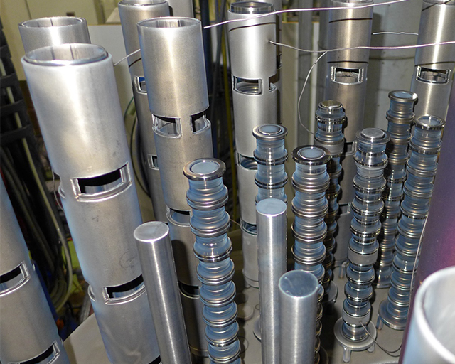 Structure of a sample batch with towers of bearing rings and assigned thermal elements: In the background, outer rings with sleeves for supporting the towers and cutouts as gas windows; in the foreground, inner rings mounted on core bar.