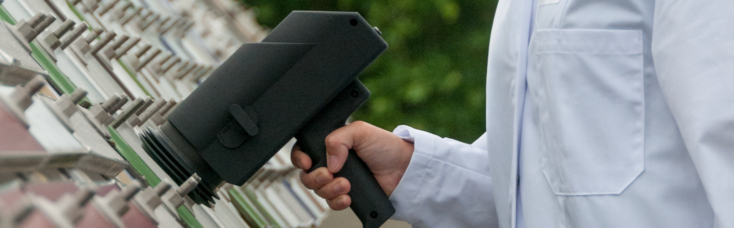 Demonstrator einer mobilen Messpistole mit lumineszenter Trägerfolie zur Bestimmung der Alterung photokatalytischer Oberflächen bei Freilandbewitterung.