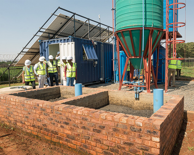 Demonstrationsanlage in Südafrika: Container, Solar-Paneele, Wassertanks und Schlammtrocknung.