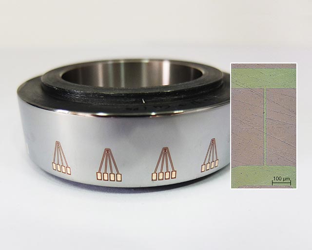 Steel ring with sensor structures for temperature measurement and microscope image of the 10 µm thick sensor structure (right).