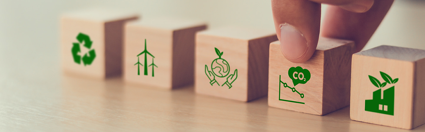 Net zero and carbon neutral concept. Net zero greenhouse gas emissions target. Climate neutral long term strategy. Hand put wooden cubes with decrease carbon emission icon and green icon. 