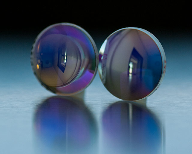 Plano-convex lense coated with a bandpass filter (at 670 nm). The coating has a special gradient, which ensures a constant spectral position of the central wavelength on the lense regardless of the position. The light in the remaining spectral range (340–1100 nm) is heavily blocked. Total coating thickness 22 micrometer, number of coatings.