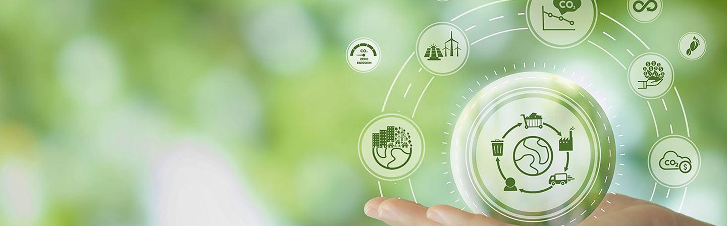 A hand holds a translucent, spherical representation of a circular system for sustainability, surrounded by various symbols illustrating ecological processes.