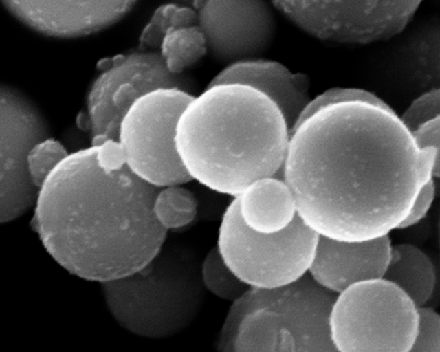 Variety of materials in plasma particle technology: Microscope image of spherical copper particles.